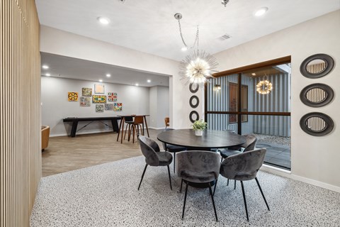 a dining area with a round table and chairs and a glass sliding door
