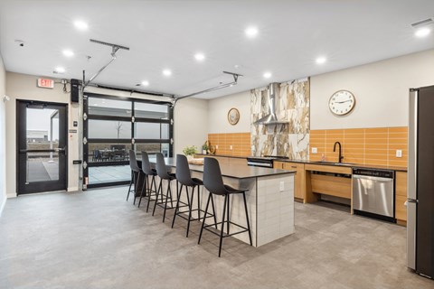 a kitchen with an island and chairs in front of a door