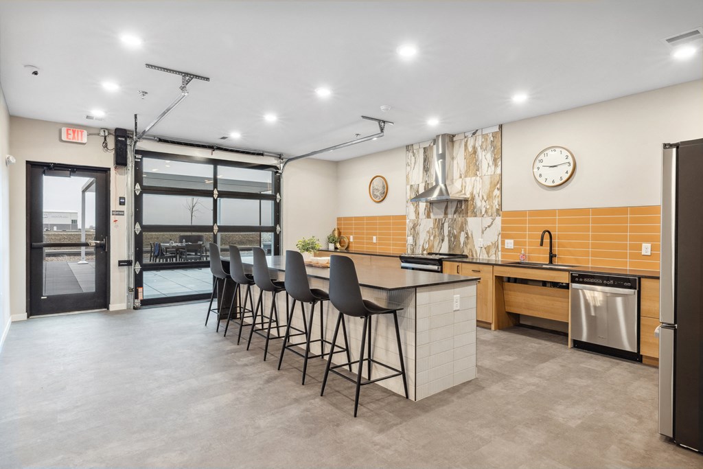 a kitchen with an island and chairs in front of a door