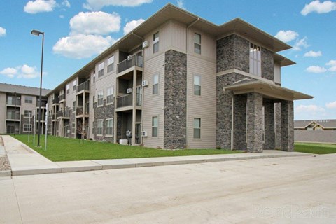 an apartment building with a sidewalk and grass