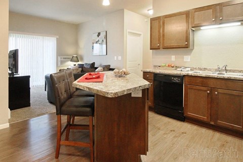 a kitchen and living room with a marble counter top