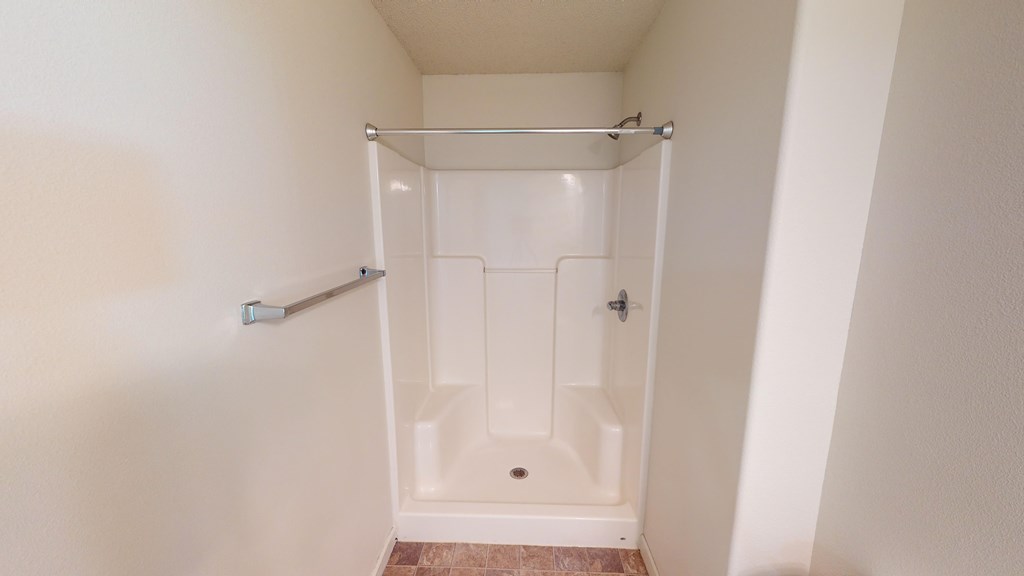 A white bathroom with a walk-in shower.