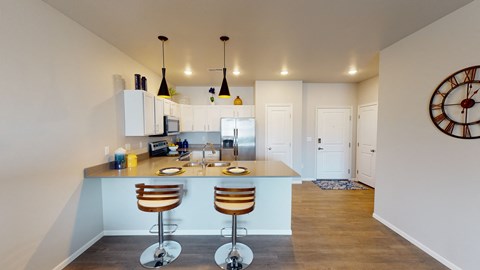 a kitchen with a breakfast bar and a counter top with three stools
