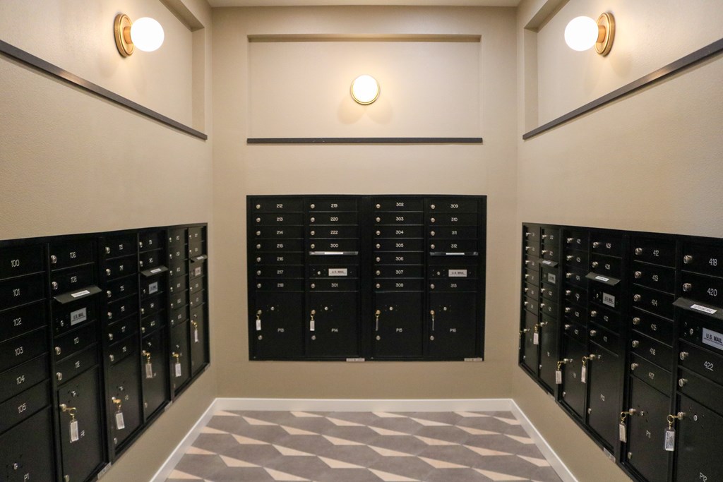 A room with a large number of black mailboxes on the walls.