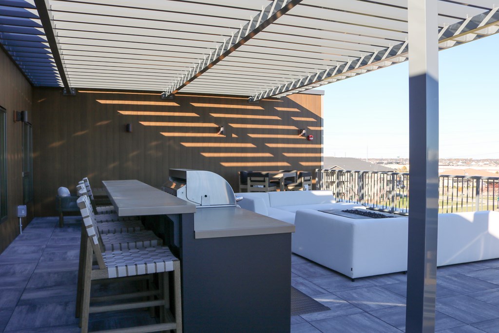 A patio with a table and chairs under a roof.