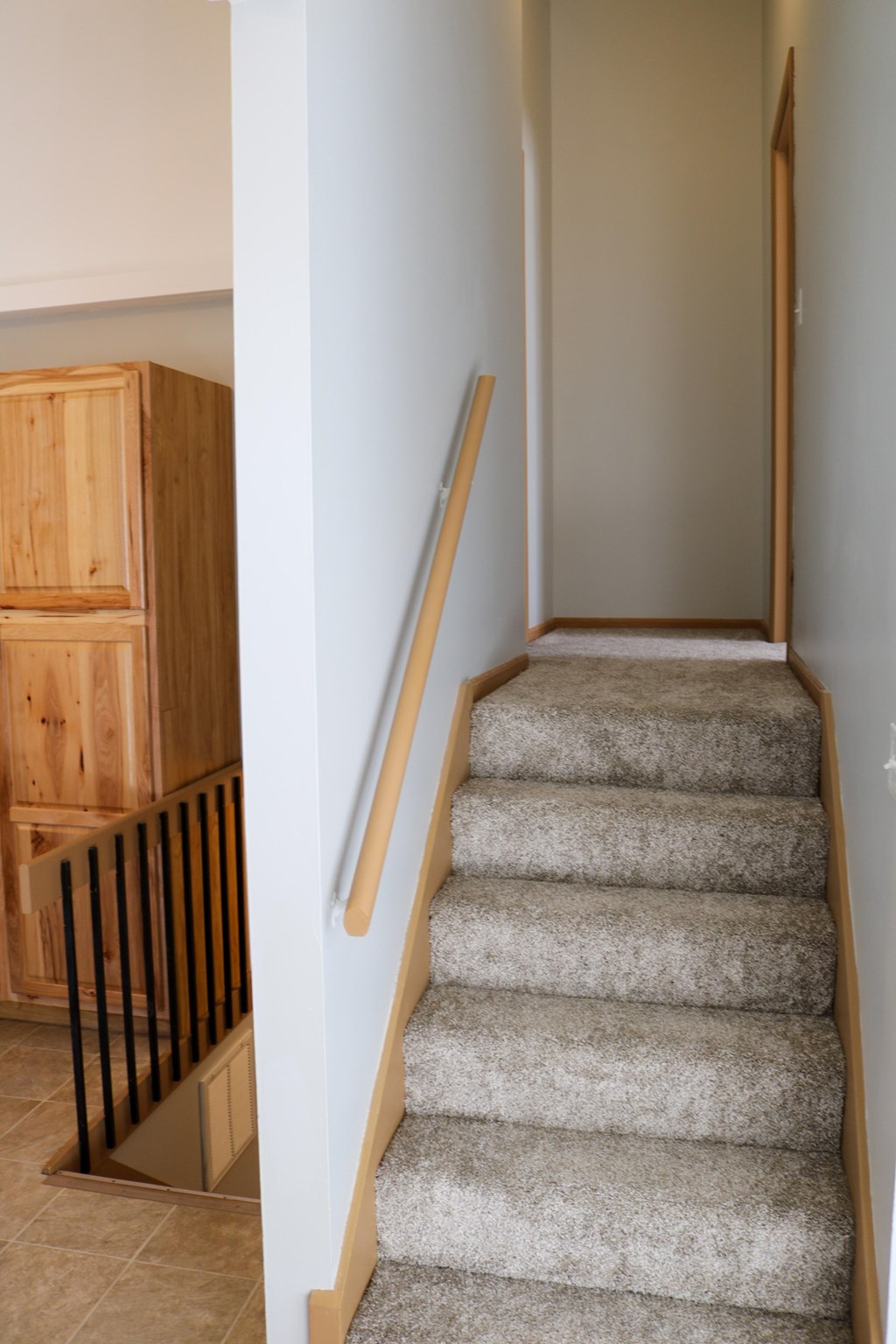 A staircase with a carpeted runner and wooden handrails.