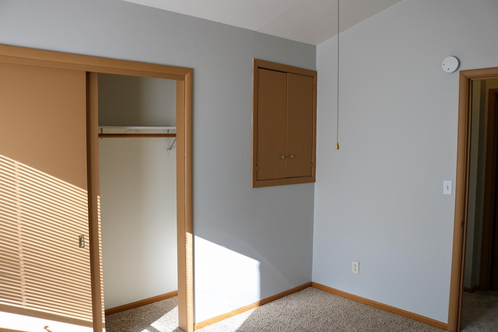 A room with a brown door and a white wall.