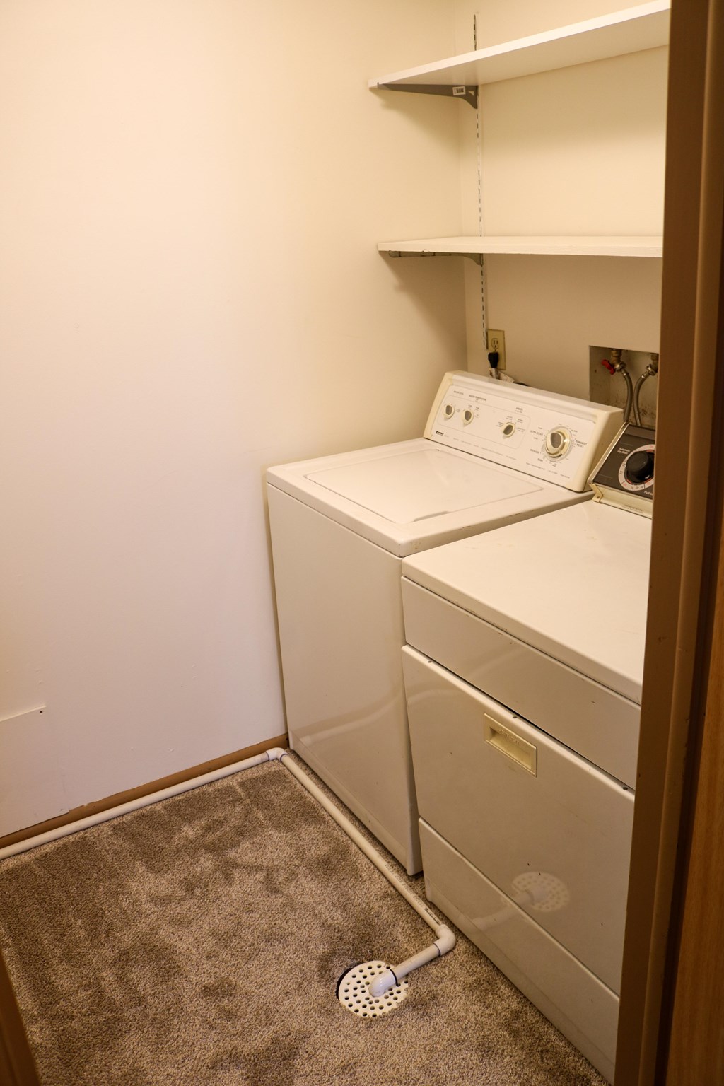 A white washing machine and dryer in a small laundry room.
