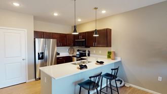 a kitchen with a white counter top and a stainless steel refrigerator