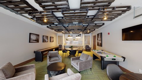 a living room with couches and chairs and a pool table