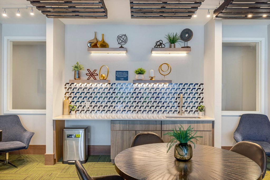 a room with a table and chairs and a bar in the back at Northern Lights a Lifestyle-Driven Community, West Fargo, ND, 58078