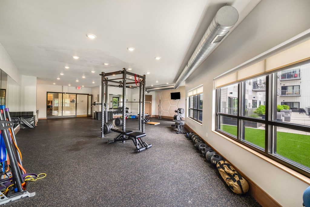 a gym with weights and other equipment and large windowsat Northern Lights a Lifestyle-Driven Community, North Dakota