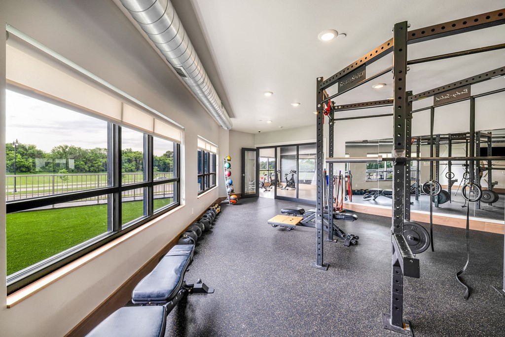 a gym with windows and weights machines and a view of the grassat Northern Lights a Lifestyle-Driven Community, West Fargo, ND, 58078