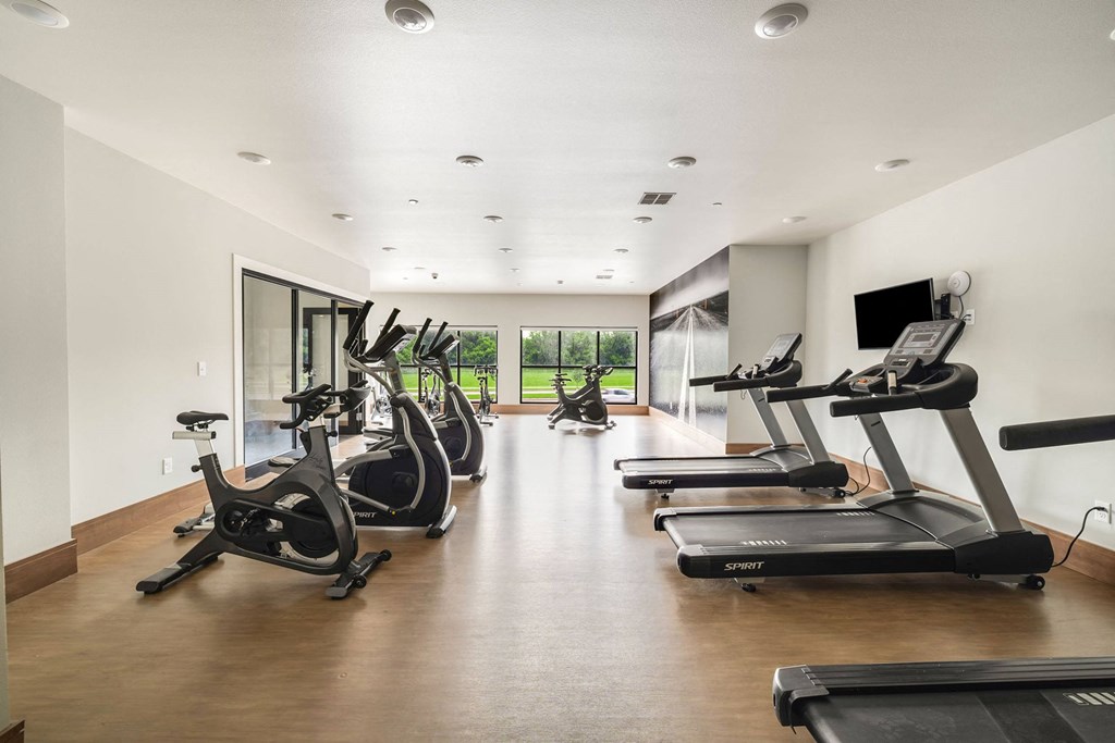 a gym with treadmills and a tv on the wall a gym with treadmills and a tv on the wallat Northern Lights a Lifestyle-Driven Community, West Fargo, North Dakota