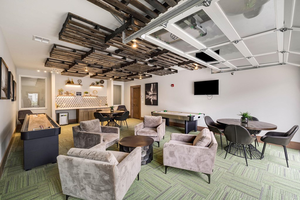 a lounge area with couches chairs and tables and a projection screen on the ceilingat Northern Lights a Lifestyle-Driven Community, West Fargo, North Dakota