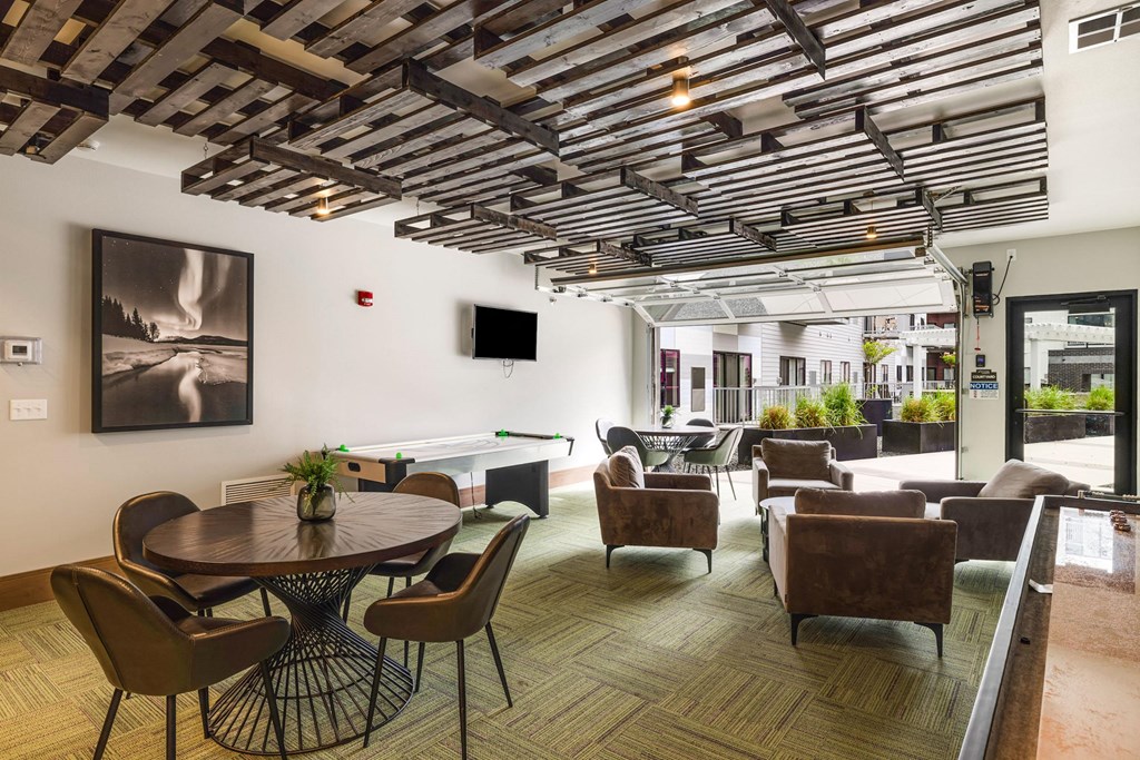 a lounge area with tables chairs and chairs and a televisionat Northern Lights a Lifestyle-Driven Community, West Fargo, 58078
