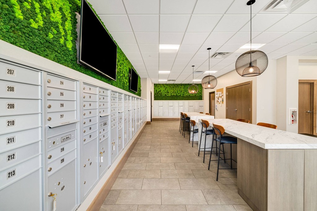 a long hallway with lockers and a table with chairs at Northern Lights a Lifestyle-Driven Community, West Fargo, ND, 58078