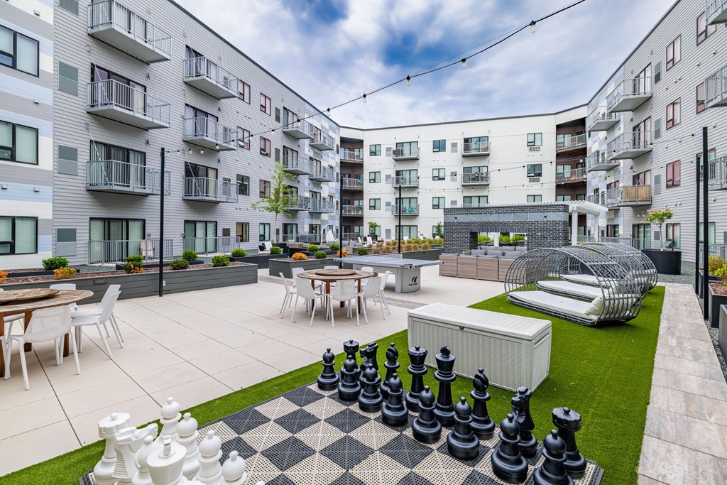 an apartment patio with tables and chairs and a large chess setat Northern Lights a Lifestyle-Driven Community, West Fargo, North Dakota