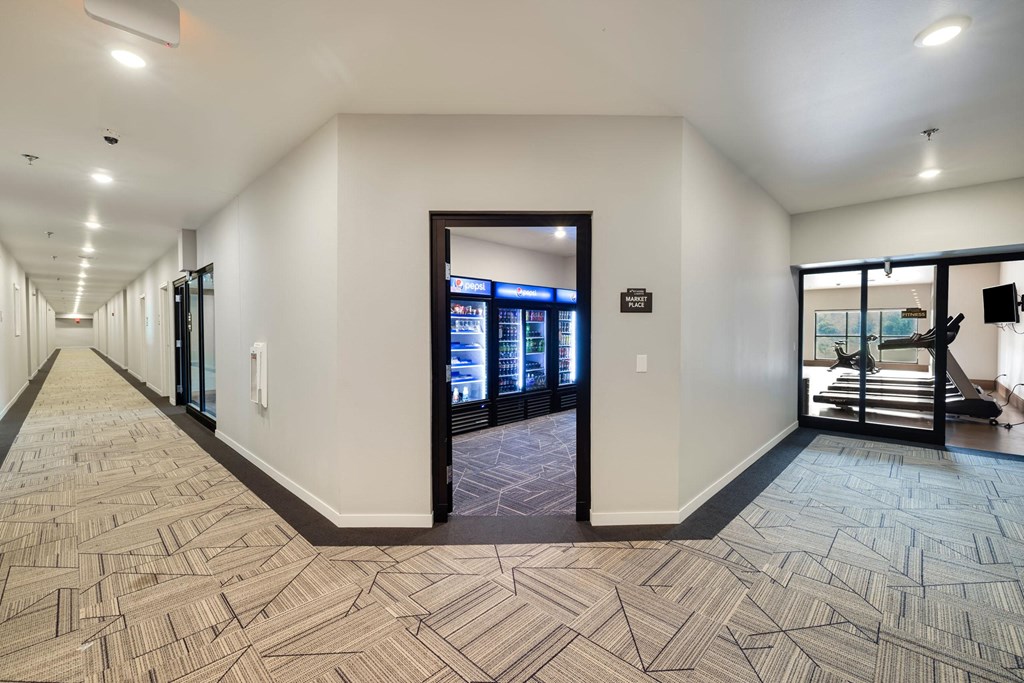 a long corridor with doors and vending machines in a buildingat Northern Lights a Lifestyle-Driven Community, West Fargo, 58078
