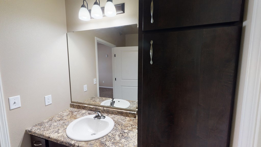 A bathroom with a sink and mirror.