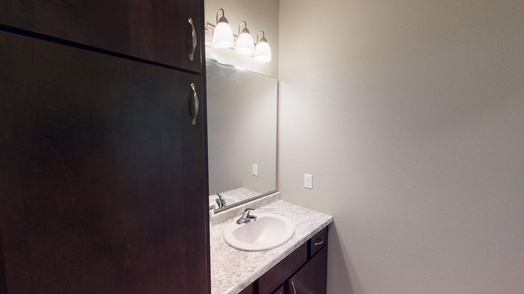 A bathroom with a sink and mirror.
