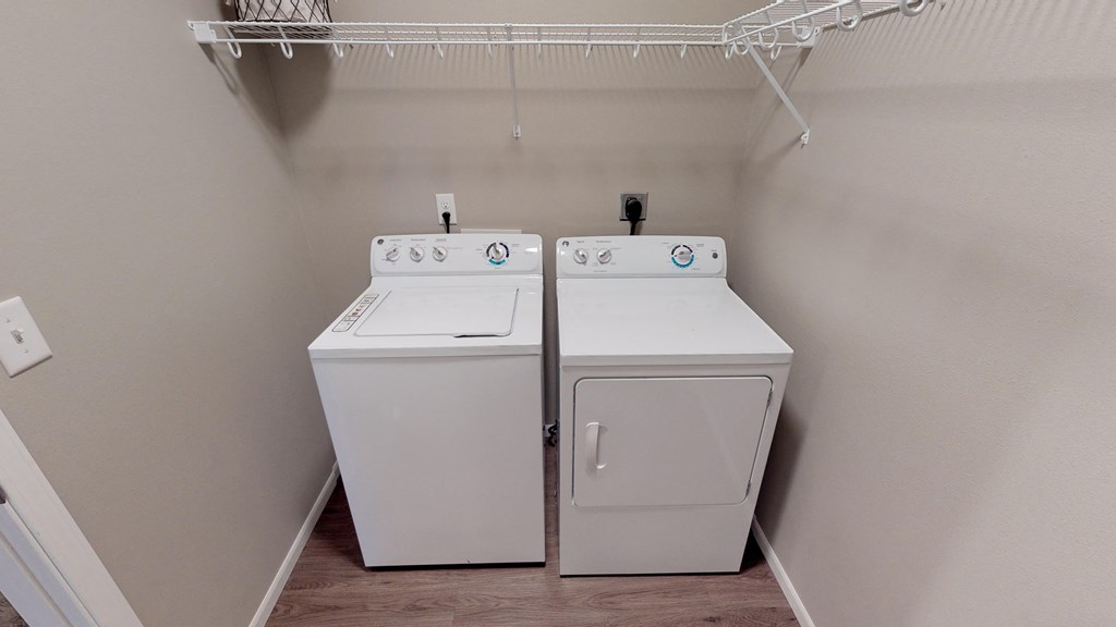 Two white washing machines in a laundry room.