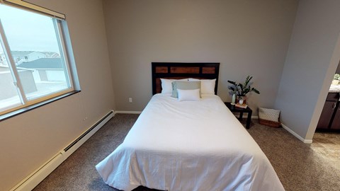 A bedroom with a large bed and a window.