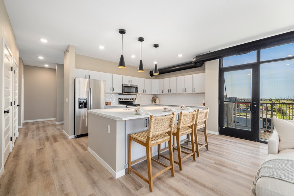 A modern kitchen with wooden floors and furniture.