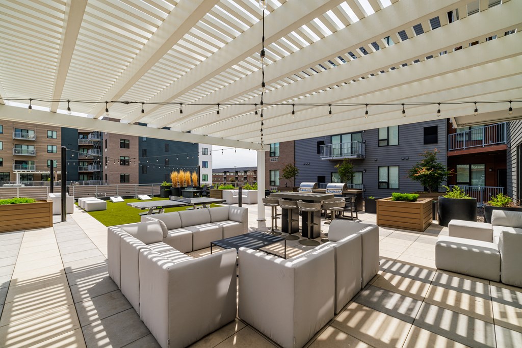 a lounge area with white couches and tables under a white roof at EagleRidge Plaza Residences, Fargo, North Dakota