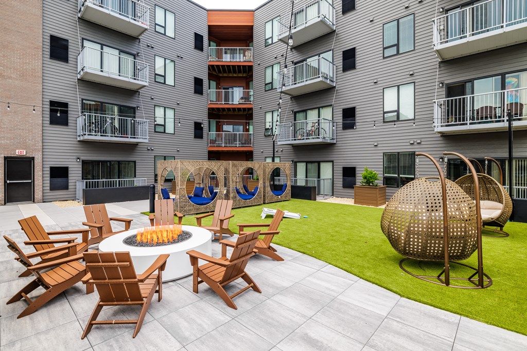 an outdoor patio with chairs and a fire pit at an apartment building at EagleRidge Plaza Residences, Fargo, 58104
