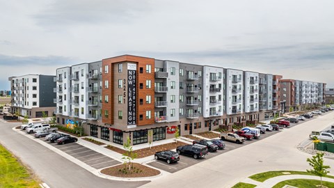 a large apartment building with cars parked in front of it