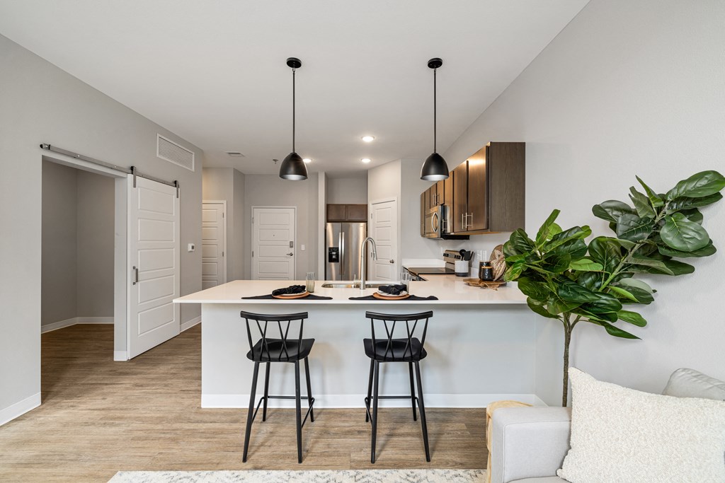 a kitchen with a white counter top and two black stools at EagleRidge Plaza Residences, Fargo, ND, 58104
