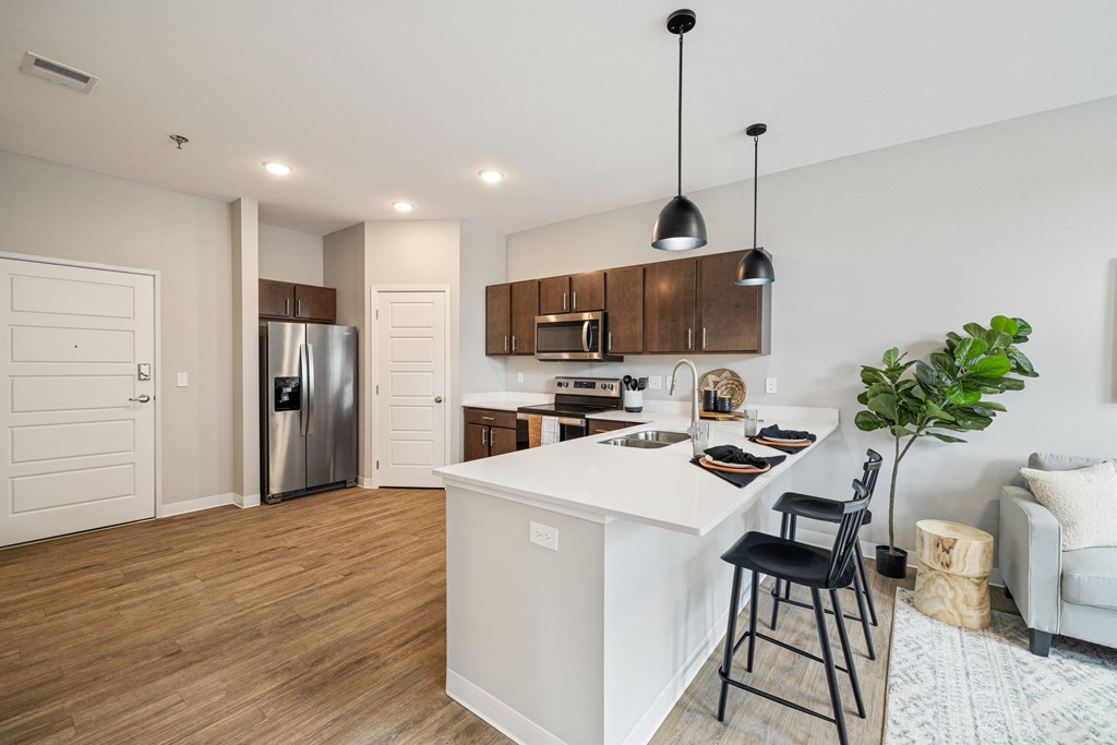 a kitchen with a white island and a stainless steel refrigerator at EagleRidge Plaza Residences, Fargo, 58104