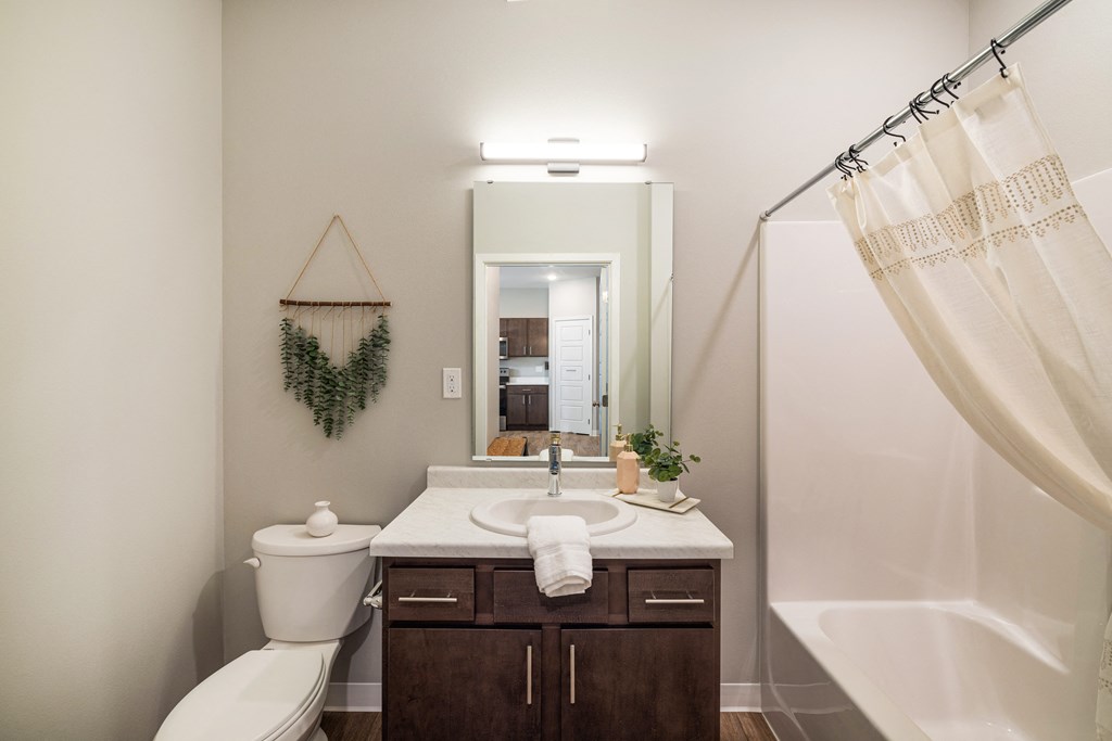 a bathroom with a toilet sink and shower and a mirror at EagleRidge Plaza Residences, Fargo, ND, 58104