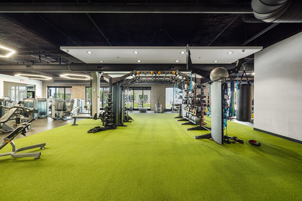 a gym with a green carpet and weights and exercise equipment at EagleRidge Plaza Residences, Fargo, ND, 58104