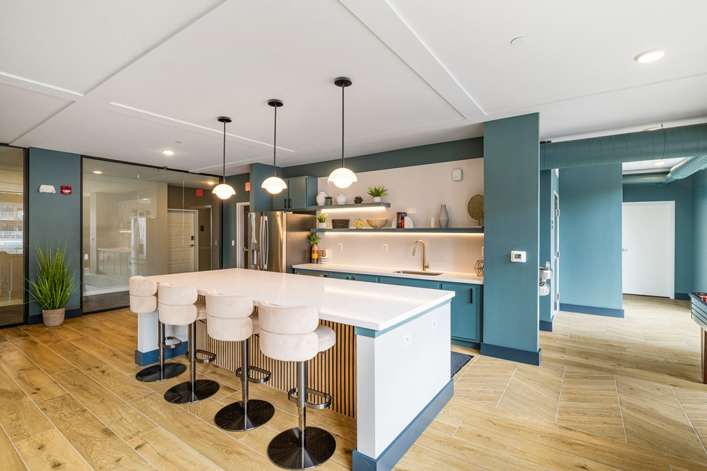 a kitchen with blue walls and a white island with bar stools at EagleRidge Plaza Residences, Fargo, ND