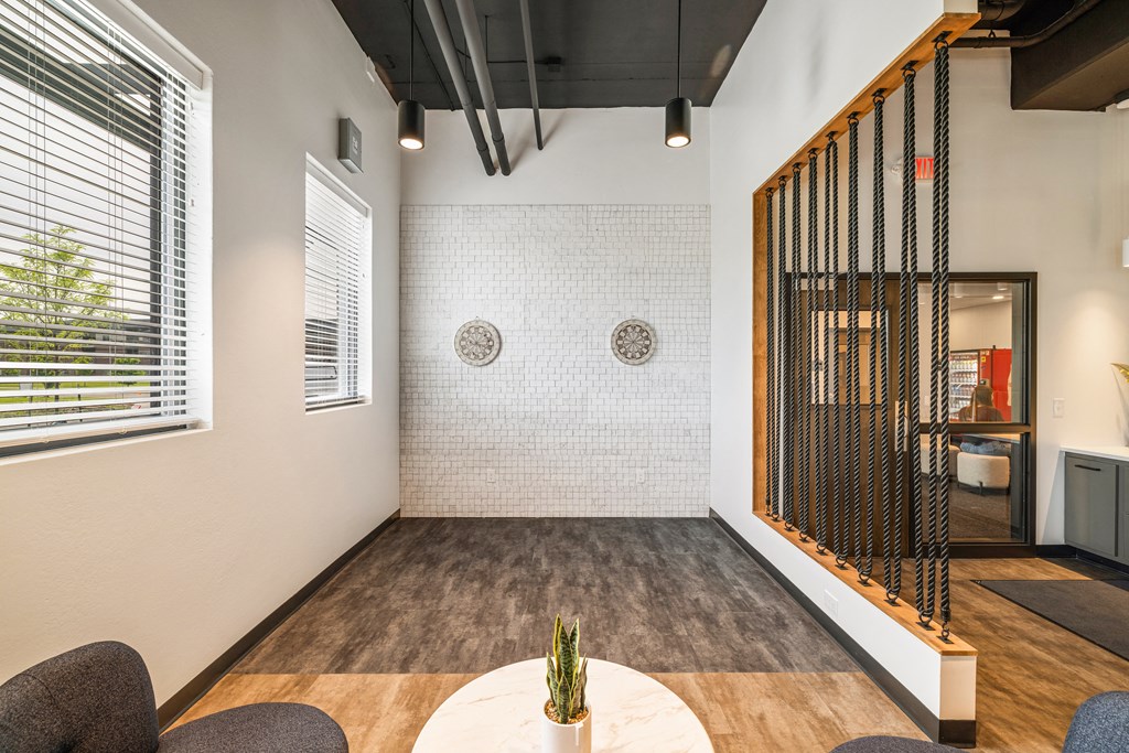 a room with a table and chairs and a wall with a screen at EagleRidge Plaza Residences, Fargo