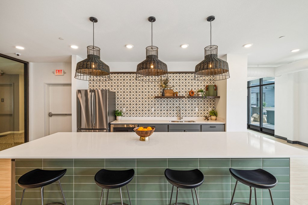 a kitchen with a white counter top and black stools at EagleRidge Plaza Residences, North Dakota