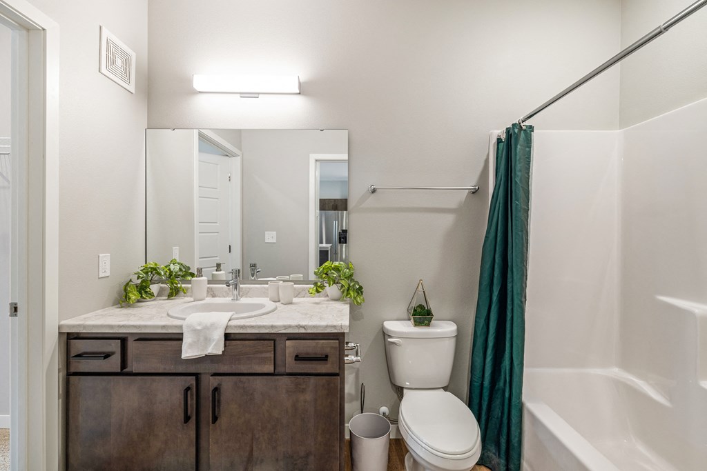 a bathroom with a shower toilet and sink and a mirror at EagleRidge Plaza Residences, Fargo, North Dakota
