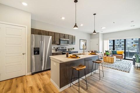 a kitchen with a large island and a stainless steel refrigerator