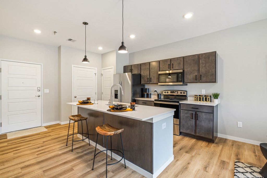an open kitchen with a large island with three stools at EagleRidge Plaza Residences, North Dakota, 58104
