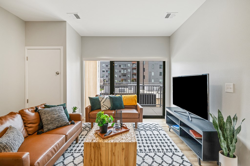 a living room with a leather couch and a television at EagleRidge Plaza Residences, Fargo, North Dakota