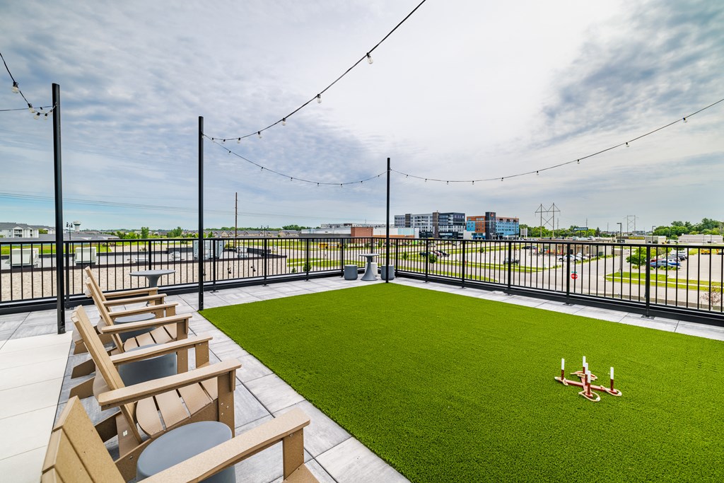 the rooftop patio with lawn chairs and a view of the city at The Standard on 32nd, West Fargo
