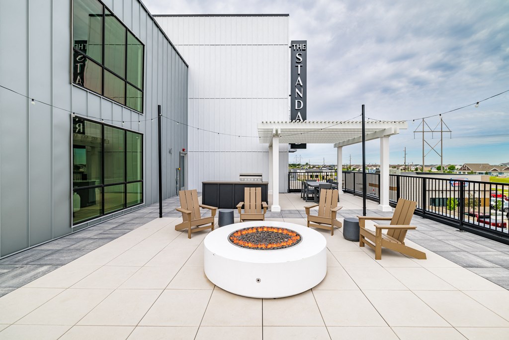 a patio with a fire pit and chairs and a building at The Standard on 32nd, West Fargo, North Dakota