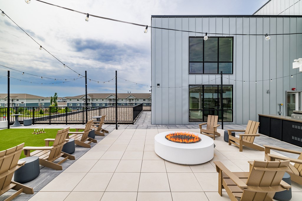 a patio with wooden chairs and a fire pit at The Standard on 32nd, West Fargo, 58078