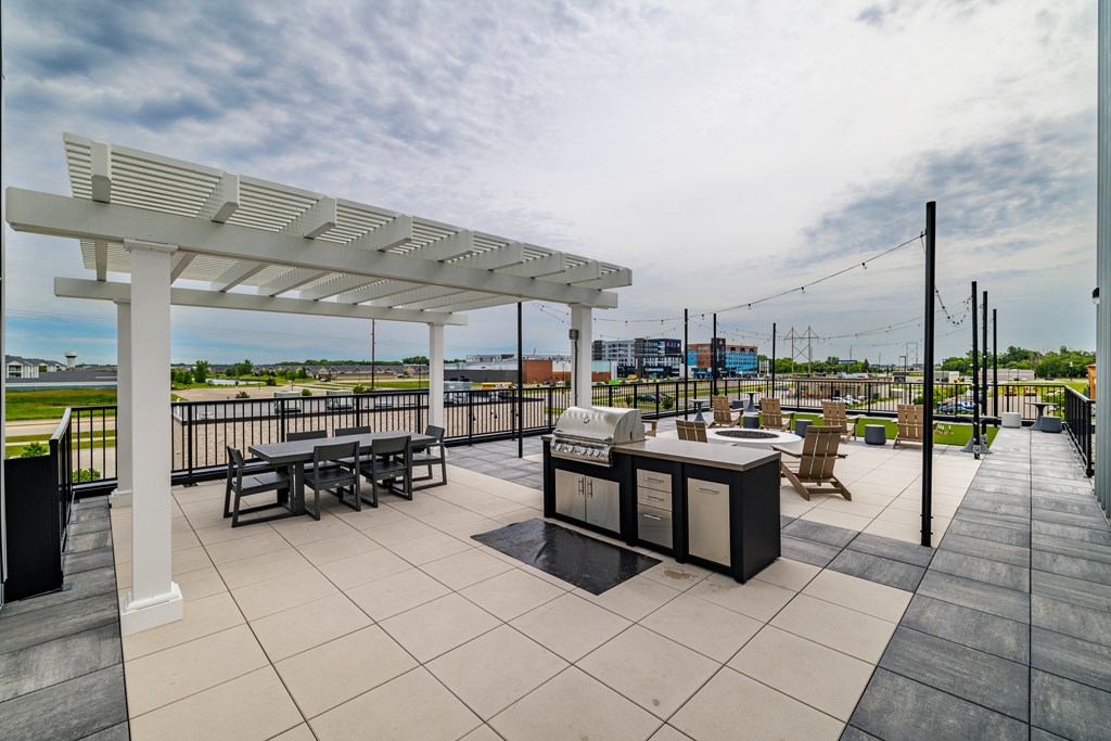 a patio with tables and chairs and a grill at The Standard on 32nd, North Dakota