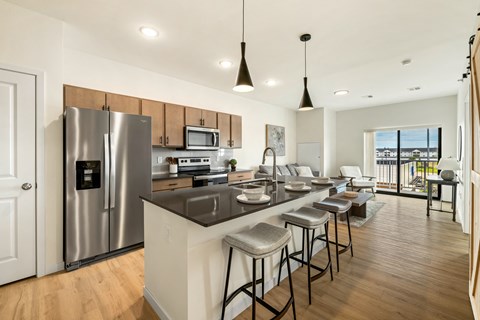 a kitchen with a large island and a stainless steel refrigerator