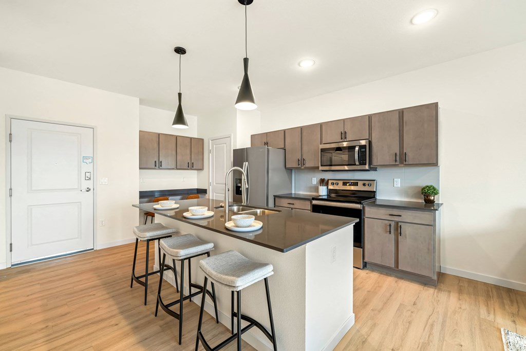 an open kitchen with a large island with three stools at The Standard on 32nd, North Dakota