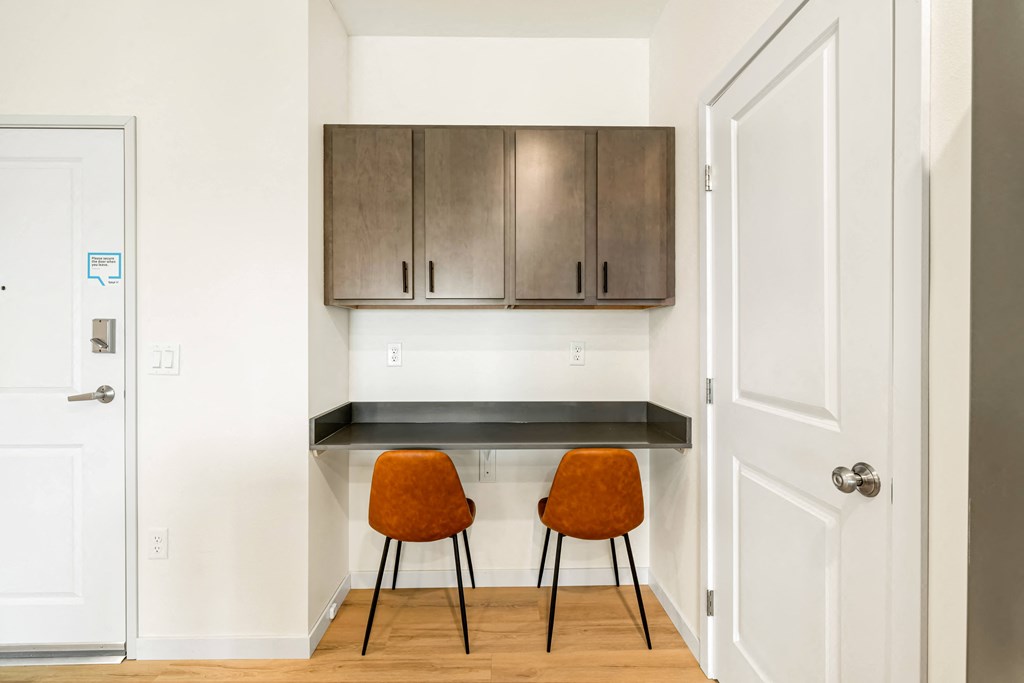 a kitchen with two chairs and a counter with cabinets at The Standard on 32nd, West Fargo, North Dakota