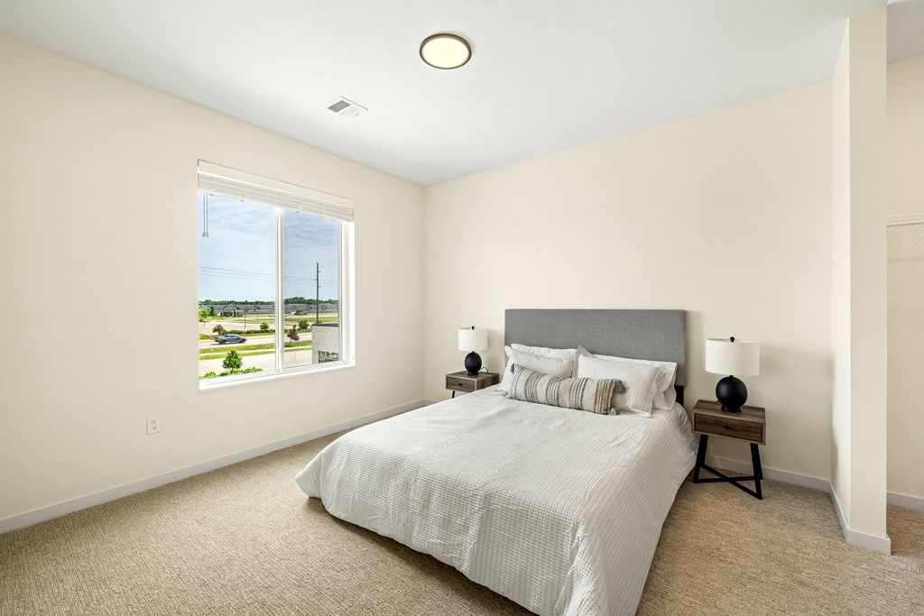 a bedroom with a large bed and a window at The Standard on 32nd, West Fargo, ND, 58078